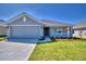 Gray house with a two-car garage and landscaped yard at 1261 Tagliamento Ln, Haines City, FL 33844