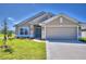 Two-story home with neutral exterior, two-car garage, and well-manicured lawn at 1257 Tagliamento Ln, Haines City, FL 33844