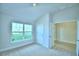 Bedroom with vaulted ceiling, large window, and access to another room at 502 Tanaro Ln, Haines City, FL 33844