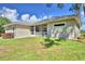Tan house with metal roof, screened porch and grassy yard at 1955 W Lake Hamilton Dr, Winter Haven, FL 33881
