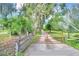 Long driveway leading to a property with a rustic wooden gate at 1955 W Lake Hamilton Dr, Winter Haven, FL 33881