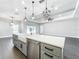Kitchen island with farmhouse sink, quartz countertop, and modern pendant lights at 1793 Lakehill Dr, Winter Haven, FL 33884