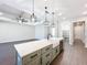 Kitchen island with farmhouse sink, quartz countertop and modern pendant lights at 1793 Lakehill Dr, Winter Haven, FL 33884