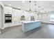 Open concept kitchen with large island, white cabinets and stainless steel appliances at 1793 Lakehill Dr, Winter Haven, FL 33884