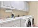 Laundry room with washer, dryer, cabinets and utility sink at 1441 S Lake Roy Dr, Winter Haven, FL 33884