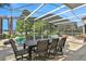 Spacious pool area with covered patio, table, chairs, and lake view at 1441 S Lake Roy Dr, Winter Haven, FL 33884