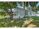 House exterior with large tree, landscaping, and pond feature at 319 N Wales Dr, Lake Wales, FL 33853