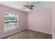 Cozy bedroom with carpet, pink walls and a large window at 625 Eisenhower St, Bartow, FL 33830