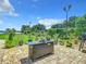 Landscaped backyard with fire pit, lush greenery, and water view at 4 Casarena Ct, Winter Haven, FL 33881