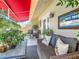 Covered balcony with wicker furniture and lush plants at 4 Casarena Ct, Winter Haven, FL 33881