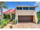 Exterior of a tan house with red tile roof, landscaping, and a brown garage door at 4 Casarena Ct, Winter Haven, FL 33881