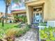 Front entry with brick walkway, landscaping, and a white bench at 4 Casarena Ct, Winter Haven, FL 33881