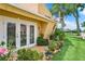 Backyard patio with white french doors and colorful potted plants at 4 Casarena Ct, Winter Haven, FL 33881