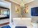 Spa-like bathroom featuring a freestanding tub and a glimpse of the bedroom at 4 Casarena Ct, Winter Haven, FL 33881