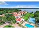 Aerial view of a waterfront community with a pool, tennis court, and many houses at 4 Casarena Ct, Winter Haven, FL 33881
