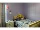 Cozy bedroom with a twin bed and a playful atmosphere, painted in lavender at 4850 St James Ct, Winter Haven, FL 33881