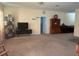 Open living room with neutral carpeting, showcasing an entertainment center and built-in shelving at 4850 St James Ct, Winter Haven, FL 33881