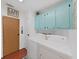 Bright laundry room with washer, dryer and light teal cabinets at 5043 Lodgewood Dr, Lakeland, FL 33810