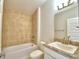 Bathroom with beige tile, a bathtub, and a vanity with a granite top at 506 Tanaro Ln, Haines City, FL 33844