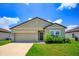 One-story house with green exterior, two-car garage, and landscaping at 4850 St James Ct, Winter Haven, FL 33881