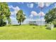 Waterfront property with dock, lush lawn, and American flag at 9650 W Lake Marion Rd, Haines City, FL 33844