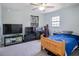 Bedroom with a wooden bed frame, desk, and TV at 997 Pearly Ridge Ln, Lakeland, FL 33809