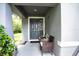 Front porch with gray door and wicker chairs at 997 Pearly Ridge Ln, Lakeland, FL 33809