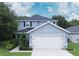 Two-story house with gray siding, white garage door, and landscaping at 997 Pearly Ridge Ln, Lakeland, FL 33809