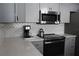 Modern kitchen with gray cabinets, quartz countertops, and stainless steel appliances at 6750 Winterset Gardens Rd, Winter Haven, FL 33884