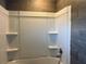 Updated bathroom with grey tile and a shower/tub combo at 6750 Winterset Gardens Rd, Winter Haven, FL 33884