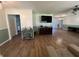 Spacious living room with hardwood floors, large TV, and access to pool at 6750 Winterset Gardens Rd, Winter Haven, FL 33884