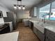 Renovated kitchen boasting gray cabinets, farmhouse sink, and stainless steel appliances at 6750 Winterset Gardens Rd, Winter Haven, FL 33884