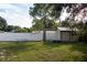 Fenced backyard with a storage shed and large tree at 15 Winterset Dr, Winter Haven, FL 33884