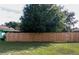 Backyard with a tall wooden fence and large tree providing privacy at 15 Winterset Dr, Winter Haven, FL 33884