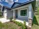 House exterior showcasing a covered porch with stone accents and landscaping at 213 Cordova Rd, Auburndale, FL 33823