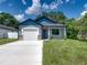 Newly built home with gray exterior, white garage door, and a landscaped lawn at 213 Cordova Rd, Auburndale, FL 33823