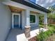 Covered front porch with stone pillars and a gray door at 213 Cordova Rd, Auburndale, FL 33823