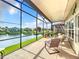 Relaxing screened lanai overlooking a lake with seating and tropical plants at 2505 Salzburg Loop, Winter Haven, FL 33884