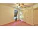 Bedroom with pink carpet, ceiling fan, window with curtains and double door closet at 317 C St, Lake Wales, FL 33853