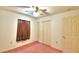 Bedroom with pink carpet, double door closet and ceiling fan at 317 C St, Lake Wales, FL 33853