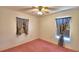 Bedroom with pink carpet, ceiling fan and two windows with curtains at 317 C St, Lake Wales, FL 33853