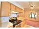 Simple kitchen with light wood cabinets, an electric stove, and access to dining area at 317 C St, Lake Wales, FL 33853