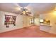 Bright living room featuring pink carpet, a ceiling fan, and access to other rooms at 317 C St, Lake Wales, FL 33853