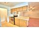 Clean kitchen with light wood cabinets, an electric stove, and a view to the living room at 317 C St, Lake Wales, FL 33853