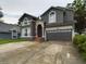 Two-story home with gray siding, two-car garage and landscaping at 5219 Mystic Point Ct, Orlando, FL 32812