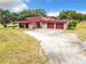 Ranch-style home with red metal roof and attached garage at 2741 Edwards Rd, Haines City, FL 33844