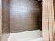 Brown tiled bathroom with a shower/tub combo and peach curtain at 2741 Edwards Rd, Haines City, FL 33844