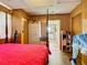 Main bedroom with a red bedspread, wood floors, and access to another room at 2741 Edwards Rd, Haines City, FL 33844