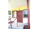 Front entry with maroon door, yellow walls, and a small porch at 2741 Edwards Rd, Haines City, FL 33844