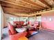 Open living room and kitchen with exposed wooden beams, brick floors, and leather furniture at 2741 Edwards Rd, Haines City, FL 33844
